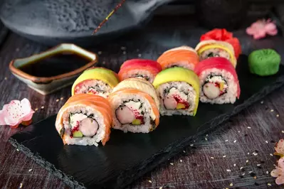 rainbow roll on a plate with soy sauce