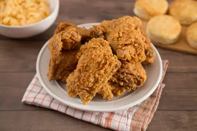 fried chicken with biscuits and mac and cheese in background