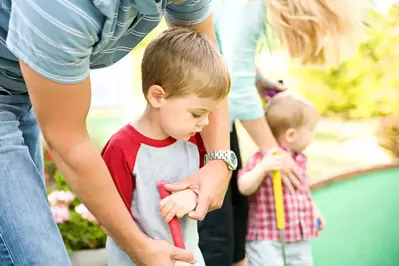 Kid playing mini golf