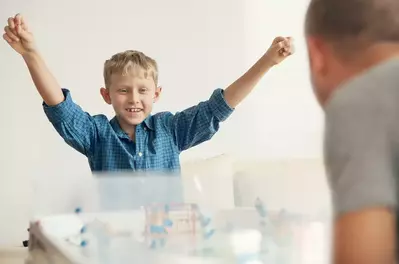 Father and son playing in a game room.