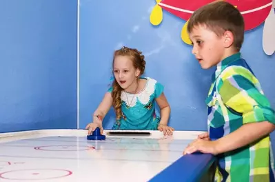 Kids playing air hockey.